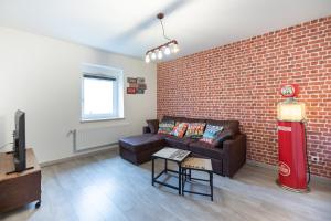 a living room with a couch and a brick wall at Résidence 3 etoiles Les thèmes Proche Lux, Metz, Cattenom in Hayange