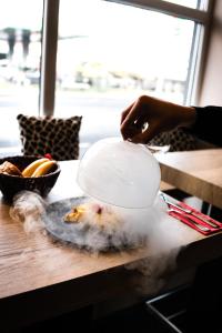 a person holding a plate of food on a table at Pension Padre in Ostrava