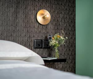 una camera da letto con un letto e un vaso di fiori su un tavolo di BLOOM Boutique Hotel & Lounge Basel a Basilea