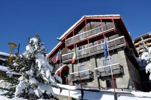 a building in the snow with flags on it at Hotel Biancaneve in Sestriere