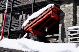 a red building with snow on top of it at Hotel Biancaneve in Sestriere