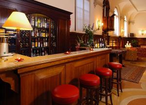 a bar with red stools in a pub at Hotel Abbazia in Venice