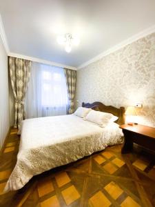 - une chambre avec un grand lit et un bureau dans l'établissement Apartment Ryadom S Ploshadiu Rynok, à Lviv