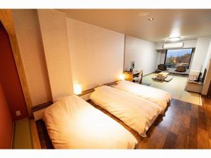 a bedroom with two beds and a living room at Kajitsu no Mori in Ichinoseki