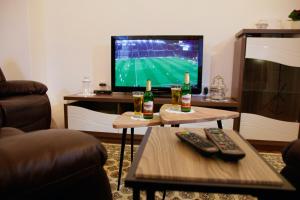 Sala de estar con 2 botellas de cerveza y TV en Little Vienna Gold Apartment, en Varaždin