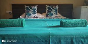 a large bed with blue sheets and pillows on it at Hotel Bonanza in Baga