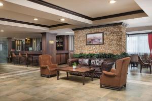 a lobby with a couch and chairs and a bar at Royal Park Hotel & Apartments in Bansko