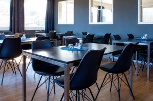 une salle à manger avec des tables et des chaises noires dans l'établissement Thon Partner Hotel Narvik, à Narvik