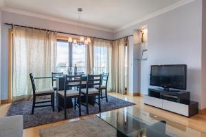 comedor con mesa, sillas y TV en LovelyStay - Modern apartment in Anjos, en Lisboa