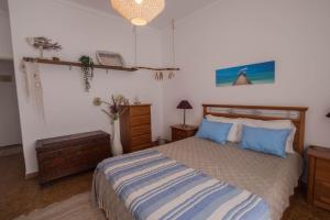 een slaapkamer met een bed met blauwe kussens bij Casa do Mar - Nazaré in Nazaré