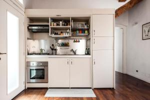 a kitchen with white cabinets and a stove at The Galileo Apartment in Pisa