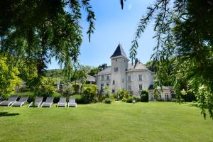 a group of chairs on a lawn in front of a castle at Château & Spa De La Commanderie in Eybens