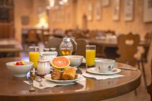 un tavolo con prodotti per la colazione e succo d'arancia sopra di Hôtel Couvent du Franciscain Centre ville a Strasburgo