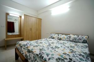 a bedroom with a bed and a dresser and a mirror at Castle JP Service Apartments in Bangalore