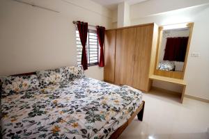 a bedroom with a bed and a cabinet and a mirror at Castle JP Service Apartments in Bangalore