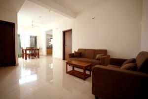 a living room with a couch and a table in it at Castle JP Service Apartments in Bangalore