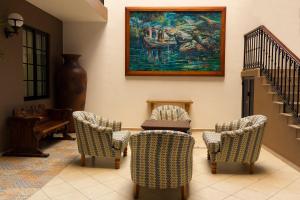 a living room with chairs and a painting on the wall at HOTEL MI SOLAR EJECUTIVO in Uruapan del Progreso