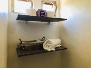 a bathroom with a shelf with a basket and towels at Cozy Little Apartment in Sayulita