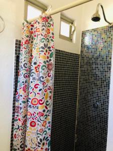 a shower curtain with flowers on it in a bathroom at Cozy Little Apartment in Sayulita