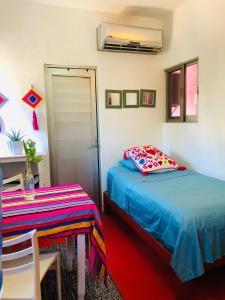 a bedroom with a bed and a table and a door at Cozy Little Apartment in Sayulita