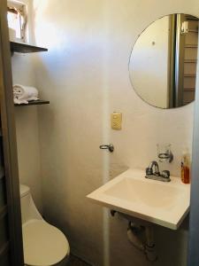 a bathroom with a sink and a toilet and a mirror at Cozy Little Apartment in Sayulita