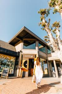 une femme en robe blanche marchant devant un magasin dans l'établissement Cavallo Point, à Sausalito