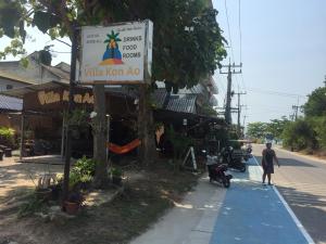 un hombre caminando por una calle al lado de un edificio en Harry's Beach Club, en Ban Phe