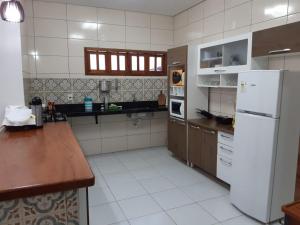 una cucina con frigorifero bianco e bancone di Casa de Praia Luis Correia a Luis Correia