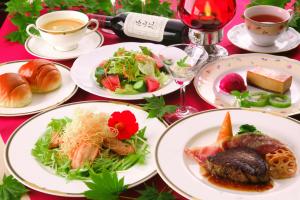 uma mesa com pratos de comida e chávenas de vinho em Chuzenji Pension em Nikko