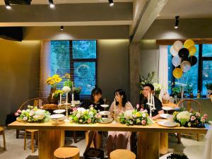 un groupe de personnes assises à une table avec des ballons dans l'établissement Moonlight Hotel, à Chengdu