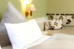 a bedroom with a white bed with pillows and a lamp at Blesius Garten in Trier