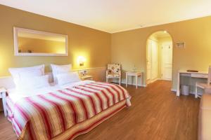 a bedroom with a large bed and a desk at Blesius Garten in Trier