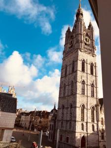 a tall tower with a clock on top of it at Evelyns Corner Duplex in Ghent