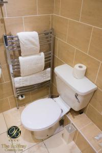 uma casa de banho com um WC branco e toalhas em The Belfray Country Inn em Derry Londonderry