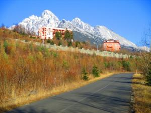 un camino vacío con montañas en el fondo en Penzion Partizan, en Vysoke Tatry - Horny Smokovec