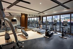 - une salle de sport avec une rangée de tapis de course et de vélos elliptiques dans l'établissement Peridot Grand Luxury Boutique Hotel, à Hanoï