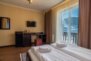 A bed or beds in a room at Amarena SPA Hotel - Breakfast included in the price Spa Swimming pool Sauna Hammam Jacuzzi Restaurant inexpensive and delicious food Parking area Barbecue 400 m to Bukovel Lift 1 room and cottages