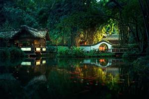 une maison au milieu d'une masse d'eau dans l'établissement Moonlight Hotel, à Chengdu