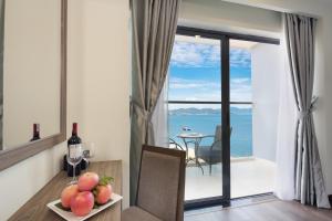 Habitación con una mesa con un bol de fruta y vistas al océano. en Xavia Hotel, en Nha Trang