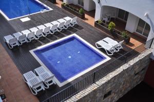 - une vue sur la piscine dotée de chaises longues et d'une piscine dans l'établissement Aparthotel Puerto Mar, à Peñíscola