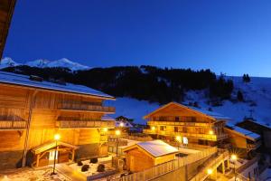 um hotel na neve à noite em Hôtel Prestige Odalys Le Chamois em La Clusaz