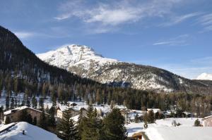 a snow covered mountain with a town in the foreground w obiekcie Chesa Chavriol w mieście Pontresina