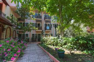 une cour d'un bâtiment avec des fleurs et des plantes dans l'établissement Club Pink Palace Hotel, à Ölüdeniz