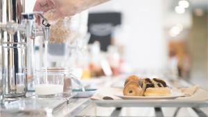 une personne prépare une assiette de pâtisseries sur un comptoir dans l'établissement Holiday Inn Express Valencia Bonaire, an IHG Hotel, à Aldaya