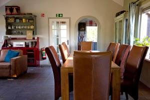 comedor con mesa de madera y sillas en Het Jachthuus - Vakantiewoning Oscar Hoeve, en Ede