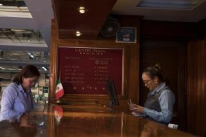 two women standing at a counter looking at their cell phones at Country Plaza in Guadalajara