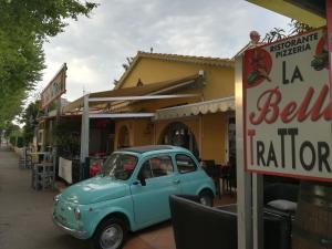 una vecchia macchina blu parcheggiata di fronte a un ristorante di Atoll Hotel restaurant a Fréjus