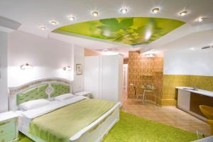 een slaapkamer met een groen bed en een badkamer bij Seven Eleven Most City Hotel&SKYTECH in Dnipro