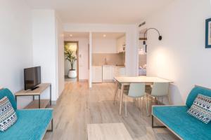 Il comprend un salon et une cuisine avec des chaises bleues et une table. dans l'établissement Aparthotel Cye Holiday Centre, à Salou