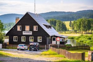 une maison noire avec deux voitures garées devant elle dans l'établissement Marvelous lake view apartments - Jezerka Lipno, à Přední Výtoň